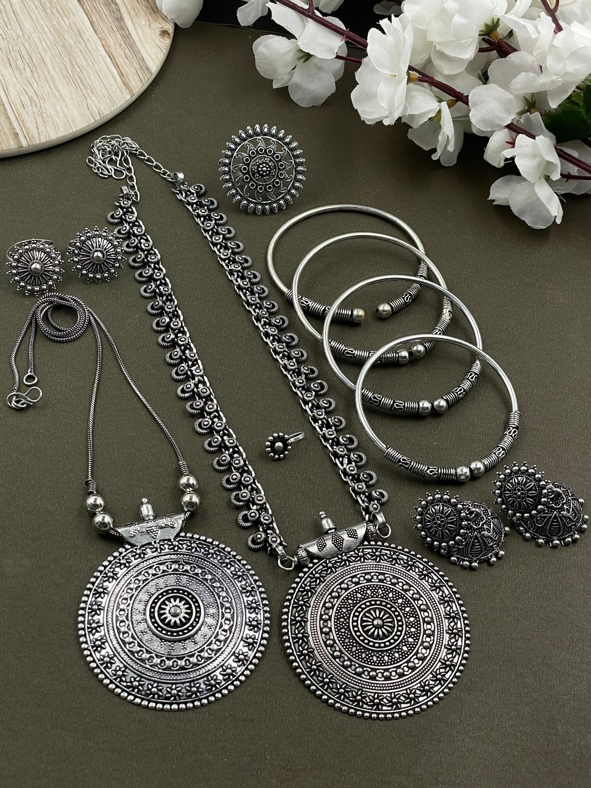 Oxidized jewelry set featuring two pendants of Round design, a ring, earrings, kada, nosepin, and toe ring, all crafted in brass with intricate detailing.