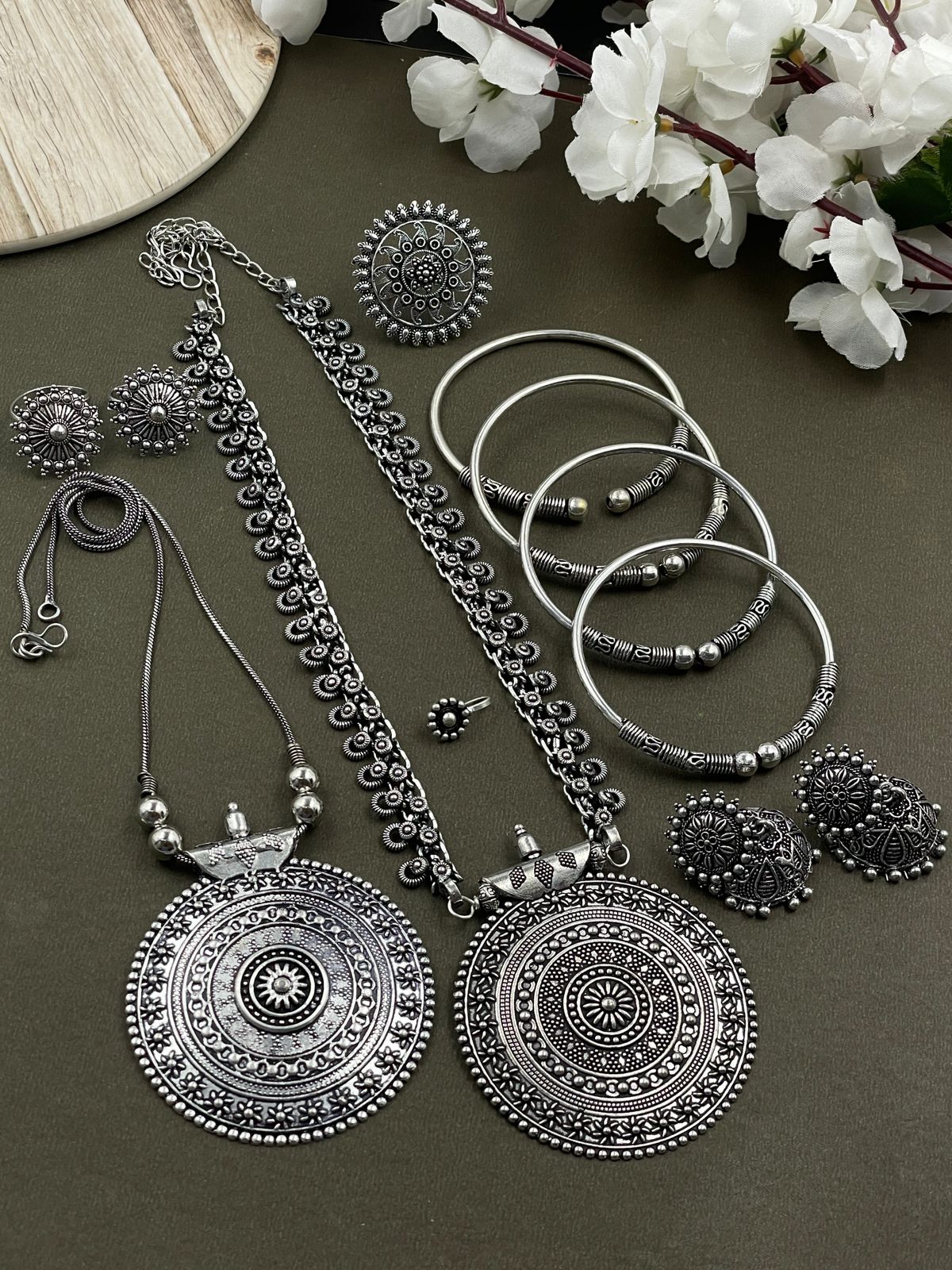 Oxidized jewelry set featuring two pendants of  Round design, a ring, earrings, kada, nosepin, and toe ring, all crafted in brass with intricate detailing.